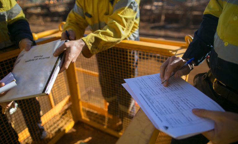 Safety workplace top view of construction supervisor wearing long-sleeve shirt a white safety helmet head protection radio communication prior reviewing sign a document and issued the permit confined.