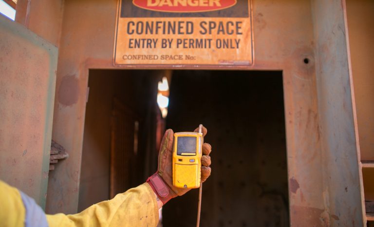 Constructor,Worker,Hand,Holding,Gas,Test,Leak,Detector,Device,While A person holds a thermometer near a door, preparing to measure the temperature before going inside.
